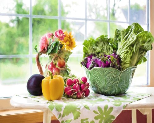 Fresh vegetables and fruits laid out on a kitchen table